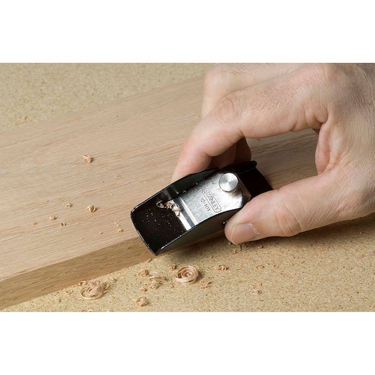 Photo of a STANLEY 12-101 block plane being used to smooth the edge of a wooden board.