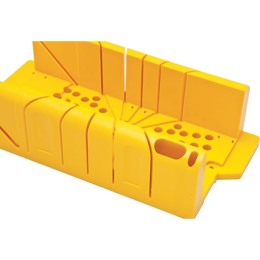 Photo of STANLEY 20-600 yellow plastic miter box, angled top-down view, with multiple slots and holes for precise cutting.