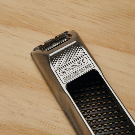 STANLEY Surform 21-399 metal hand rasp tool on a wood surface, close-up view.