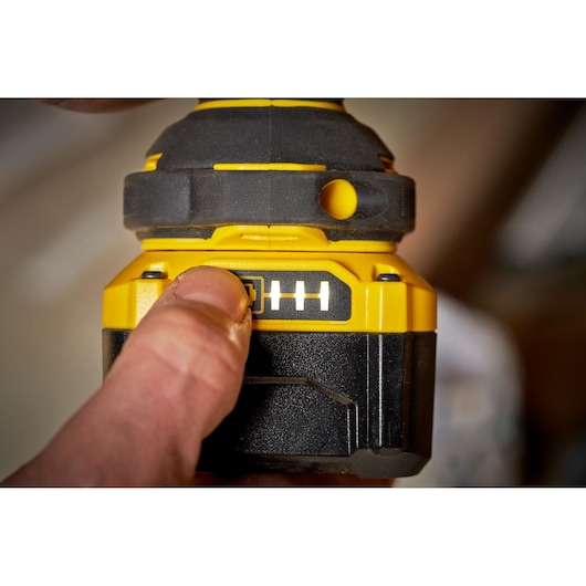 STANLEY SBW920M2K battery indicator close-up, yellow and black, with finger pressing power button.