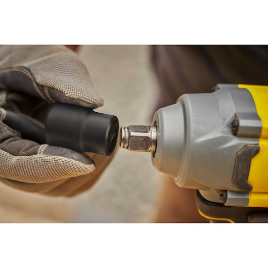 STANLEY SBW920M2K close-up photo of gloved hand attaching black socket to yellow and gray power tool.