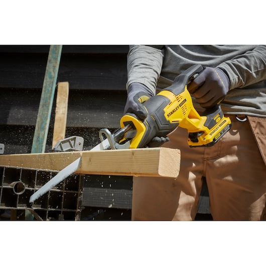 Photo of STANLEY SCR300D2K cordless reciprocating saw cutting wood, close-up, product in use.