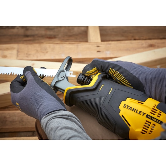 Stanley SCR300D2K reciprocating saw, close-up of blade installation, black and yellow body, gloved hands.