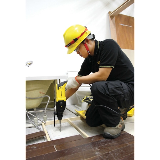 Stanley SHR263K-BR rotary hammer in use during floor installation, worker wearing safety gear.