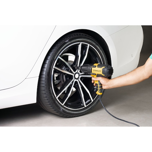 Application shot of  STANLEY corded impact wrench being used on a car wheel