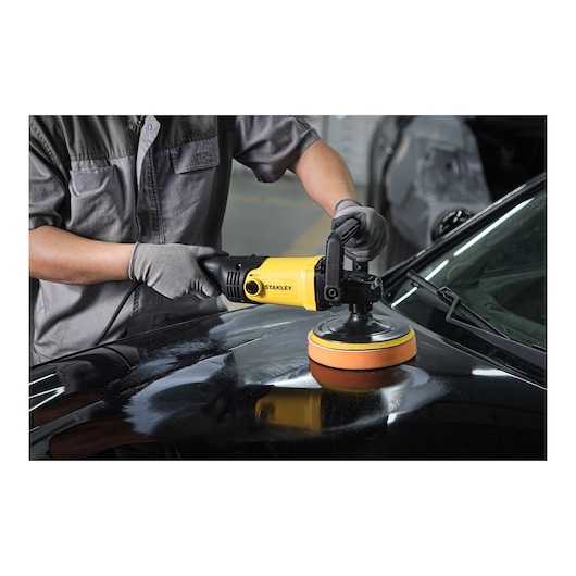 Stanley SP137 photography of yellow polisher in use on black car hood, close-up angle.